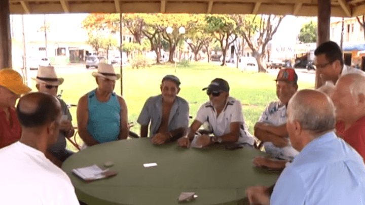 Amigos se reúnem diariamente na praça do Ilha Bela para jogar baralho